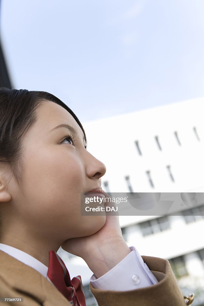 Teenage girl resting chin in hand, smiling