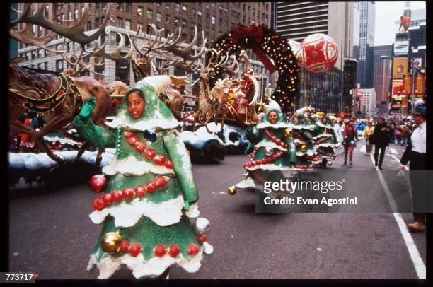 Several children dressed as Christmas trees wave at the 69th Macy's Thanksgiving Day Parade November 23, 1995 in New York City. The parade was...