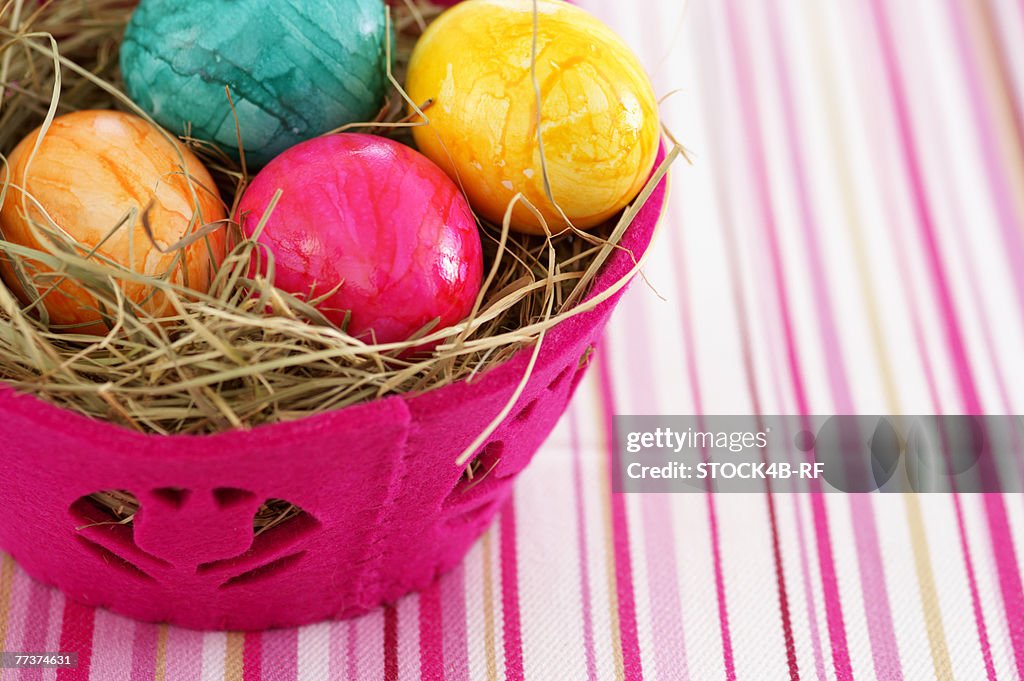 Nest made of straw with eggs in a basket, close-up