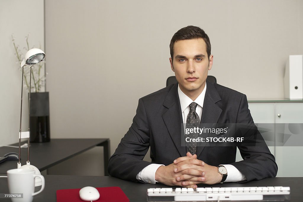 Businessman sitting at a desk, portrait