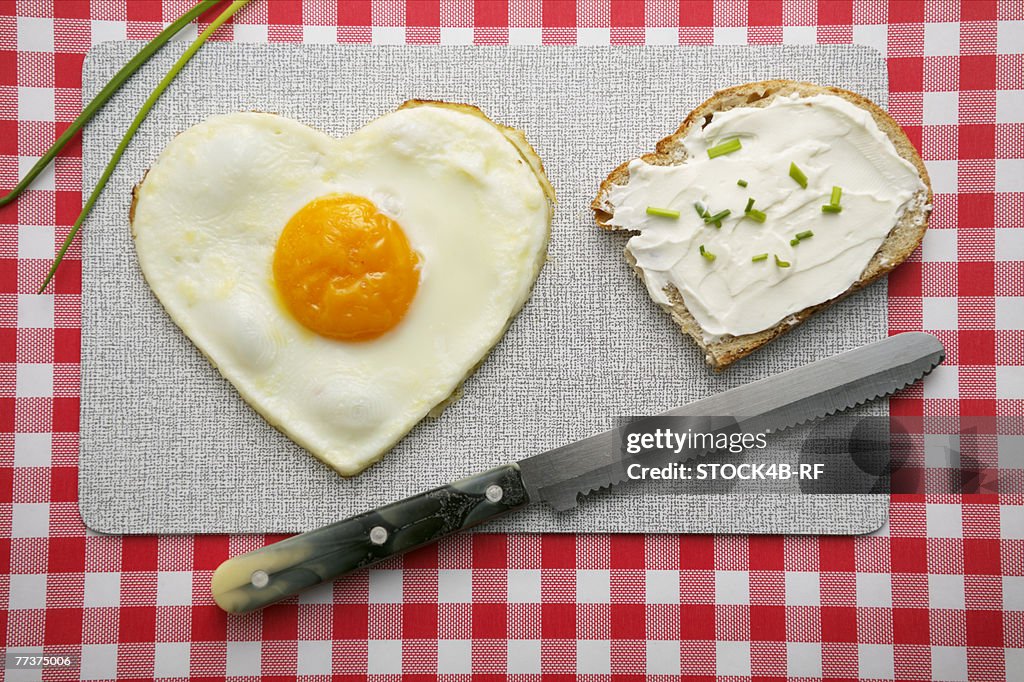 Heart-shaped fried egg and a bread with cream cheese