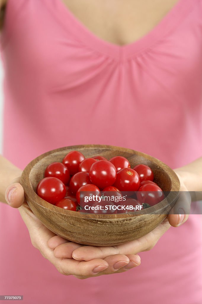 Woman holding a bowl with cherry tomatoes