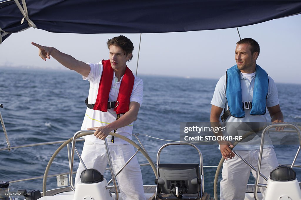 Two men steering a boat