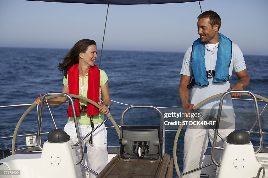Two people steering a boat