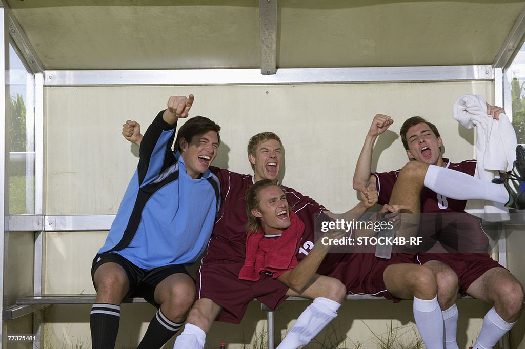 Cheering kickers sitting on substitutes' bench