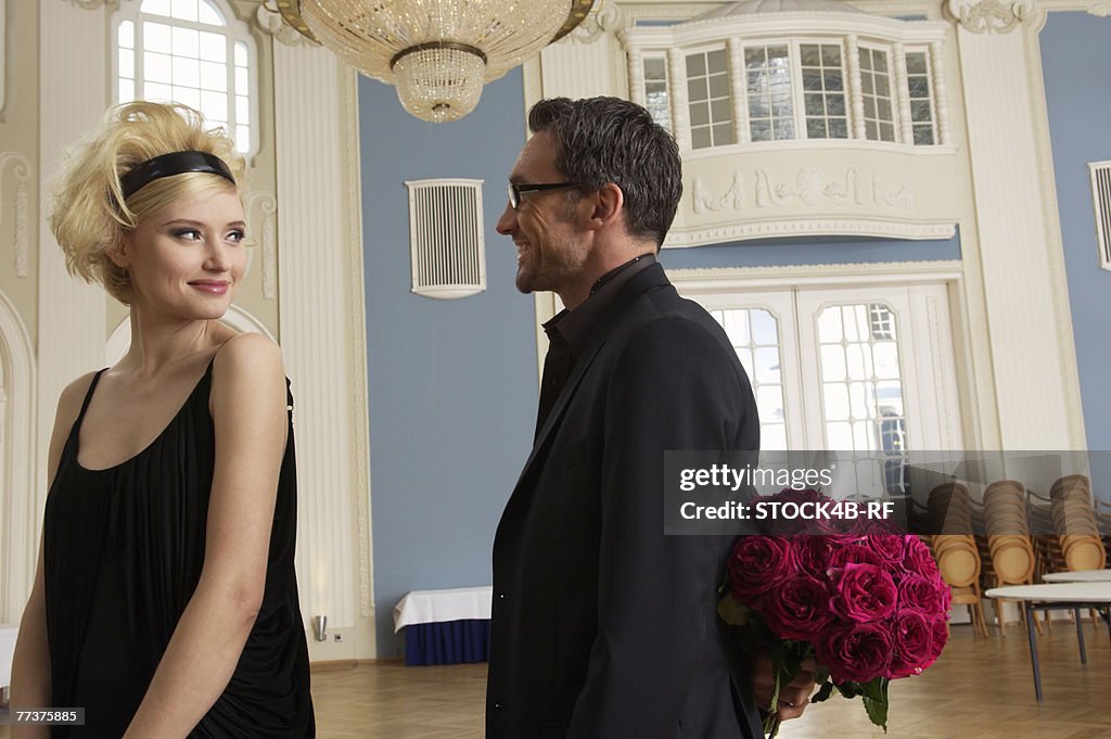 Man about to give bunch of roses to woman 