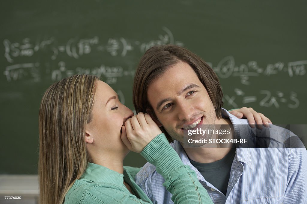 A women whispering in mans ear 