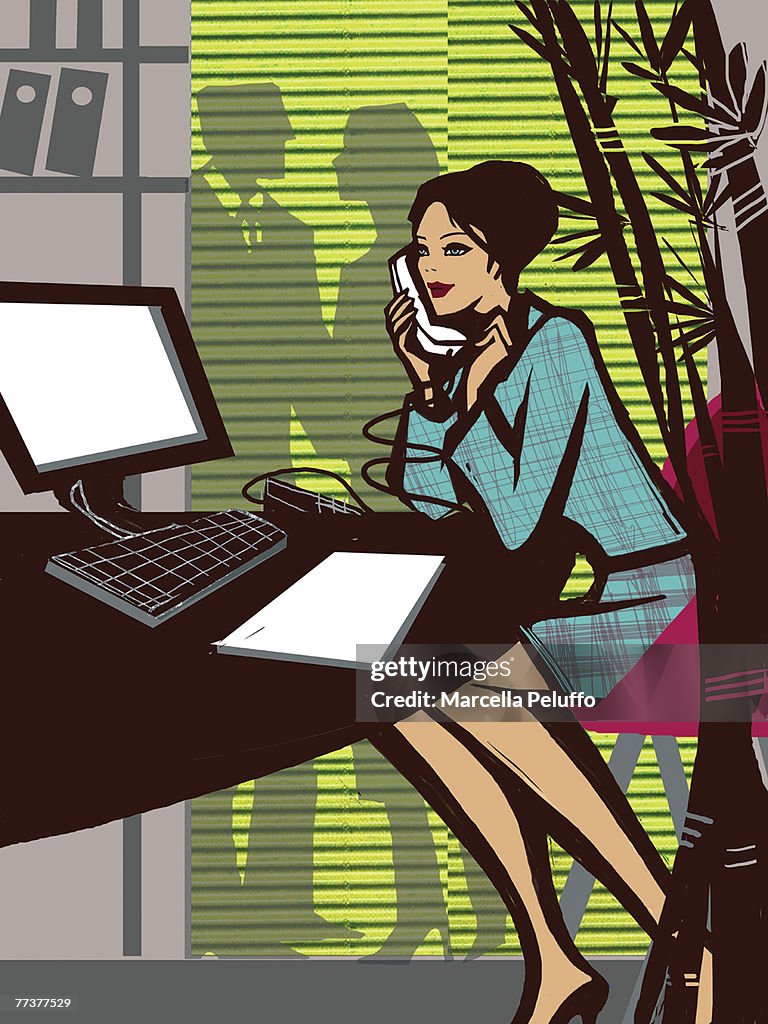 A woman talking on the phone while working in the office