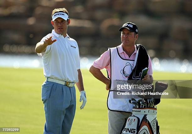 Lee Westwood of England checks the wind with his caddy Alastair McLean during the first round of the Portugal Masters at Oce?nico Victoria Clube de...