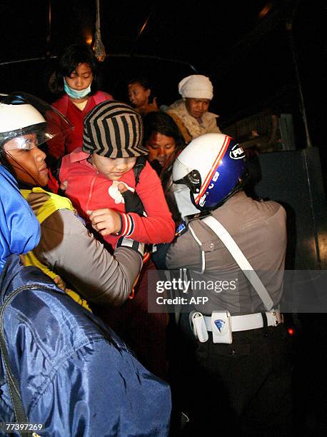 Police help villagers to get in a truck as they engage in a forced evacuation of people living on the slopes of Mount Kelut in Kediri, East Java, 18...