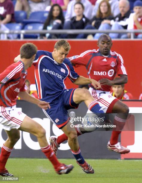 New England Revolution's Adam Cristman splits Toronto FC' Andrew Boyens, left, and Marvell Wynne during MLS action at Gillette Stadium in Foxborough,...