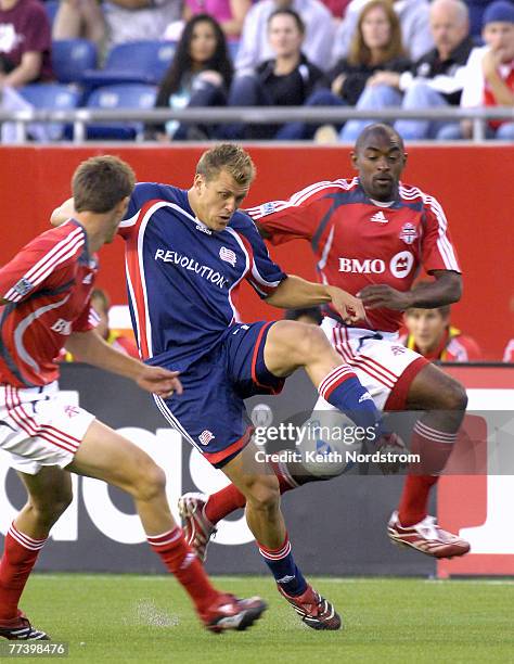 New England Revolution's Adam Cristman splits Toronto FC' Andrew Boyens, left, and Marvell Wynne during MLS action at Gillette Stadium in Foxborough,...