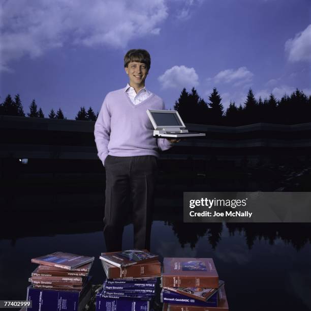 Microsoft owner and founder Bill Gates poses outdoors with Microsoft's first laptop in 1986 at the new 40-acre corpororate campus in Redmond,...