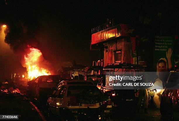 Fire erupts from a car in front of a vehicle carrying of former Pakistani prime minister Benazir Bhutto after bomb explosion in Karachi, 18 October...