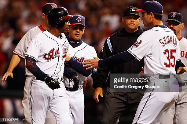 First base coach Luis Rivera and Joe Skinner hold back Kenny Lofton of the Cleveland Indians as he has words with Josh Beckett of the Boston Red Sox...