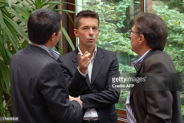 Former CEO of toy maker Smoby-Majorette Jean-Christophe Breuil speaks with unidentifed people after a press conference, 19 October 2007 in Paris....