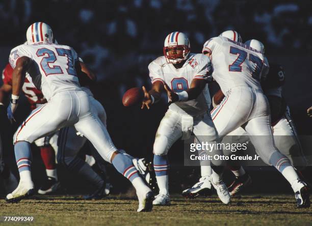 Steve McNair, Quarterback for the Tennessee Oilers passes the ball to Running Back Eddie George during the National Football Conference East game...