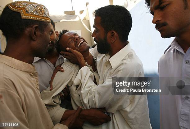 Family members grieve outside the Edhi Morgue October 19, 2007 in Karachi, Pakistan. A suicide bombing killed at least 136 people in an assassination...