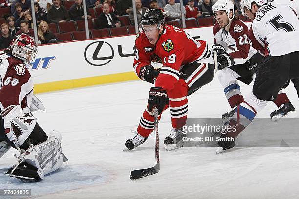 Jonathan Toews of the Chicago Blackhawks shoots and scores his second goal of the season against goalie Jose Theodore of the Colorado Avalanche at...