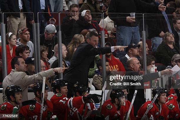 Head coach Denis Savard of the Chicago Blackhawks and staff point to a play at the United Center October 19, 2007 in Chicago, Illinois.