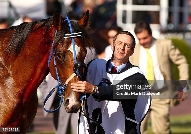 Maldivian is led back to the stables by strapper Michael Preston with trainer Mark Kavanagh close behind at the start of the Caulfield Cup during the...