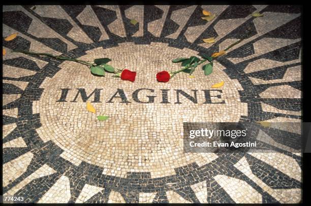 Two roses lay on the memorial to John Lennon December 2, 1995 in New York City. The memorial to Lennon in Central Park called, "Strawberry Fields"...