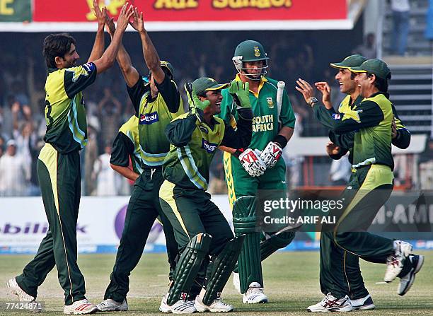 Pakistani bowler Sohail Tanveer celebrates with teammates the dismissal of South African cricketer Jacques Kallis as he walks back to the pavilion...