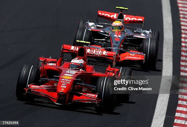 Kimi Raikkonen of Finland and Ferrari leads from Lewis Hamilton of Great Britain and McLaren Mercedes in action during the warm up session prior to...