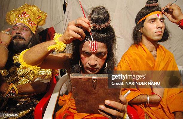 Indian artists dressed as Hindu Lord Rama , Laxman and the demon Ravana put on their make-up before performing the Ramleela, the story of Lord Rama,...