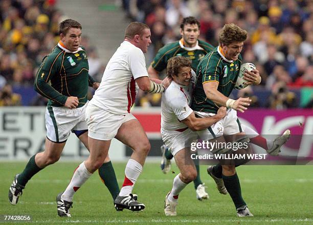 South Africa's flanker Juan Smith holds onto the ball as England's scrum-half Andy Gomarsall tackles and England's prop and captain Phil Vickery runs...