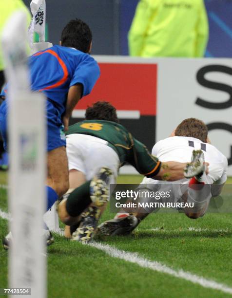 England's winger Mark Cueto scores a try, tackled by South Africa's flanker Schalk Burger, and canceled by Ireland's referee Alain Rolland during the...