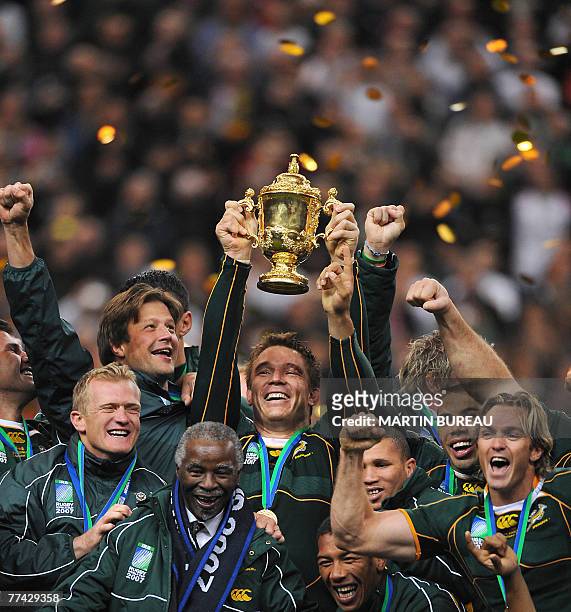 South Africa's hooker and captain John Smit, holding the William Webb Ellis cup, his teammates and South Africa president Thabo Mbeki , celebrate...