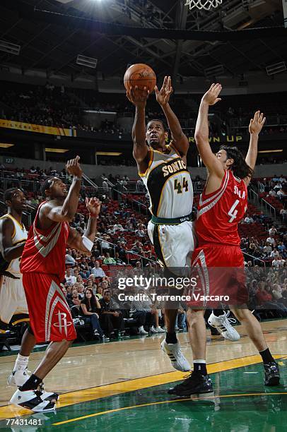 Kurt Thomas of the Seattle SuperSonics goes to the basket between the defense of Luis Scola and Tracy McGrady of the Houston Rockets in a preseason...