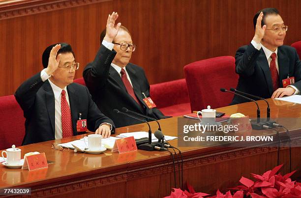 Chinese President Hu Jintao , former President Jiang Zemin and Premier Wen Jiabao raise their hands to vote during the closing session of the ruling...