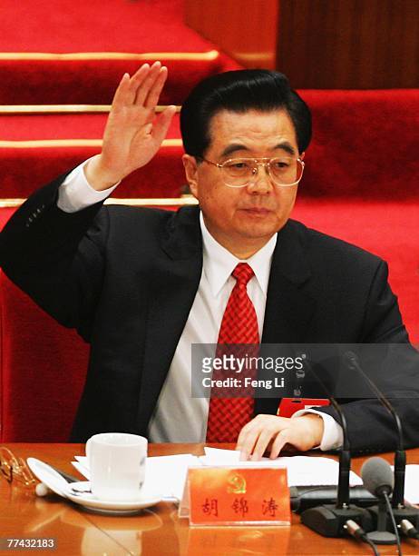 Chinese President Hu Jintao raises his hand to vote during the Chinese Communist Party Congress at the Great Hall of the People on October 21, 2007...