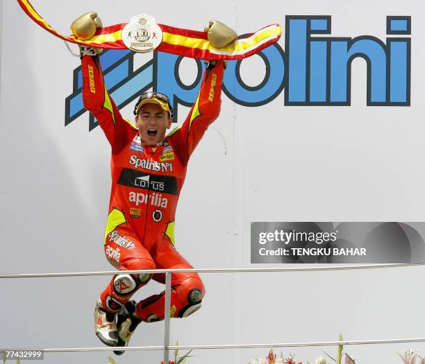 Spanish 250cc rider Jorge Lorenzo , wearing gold boxing gloves and a championship belt provided by his teammates, jumps in jubilation after cliching...