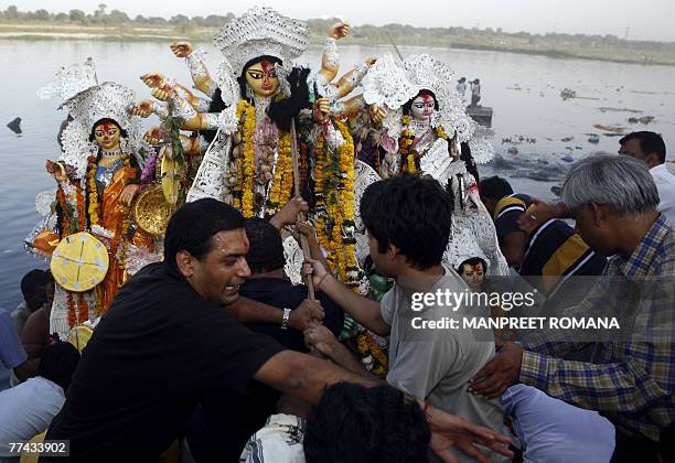 Indian Hindu devotees push an idol of the Goddess Durga into the River Yamuna for immersion in New Delhi, 21 October 2007, on the final day of the...