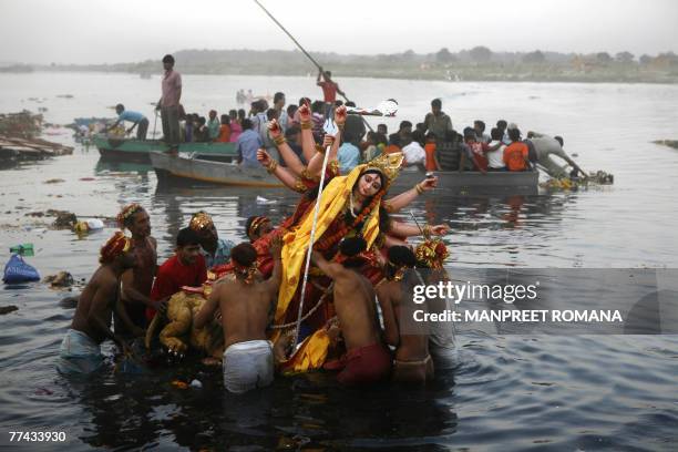 Indian Hindu devotees carry an idol of the Goddess Durga into the River Yamuna for immersion in New Delhi, 21 October 2007, on the final day of the...