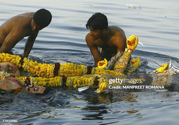 Indian Hindu devotees immerse an idol of the Goddess Durga in the River Yamuna in New Delhi, 21 October 2007, on the final day of the Durga Puja...