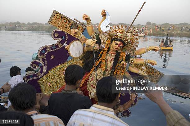 Indian Hindu devotees carry an idol of the Goddess Durga for immersion into the River Yamuna in New Delhi, 21 October 2007, on the final day of the...