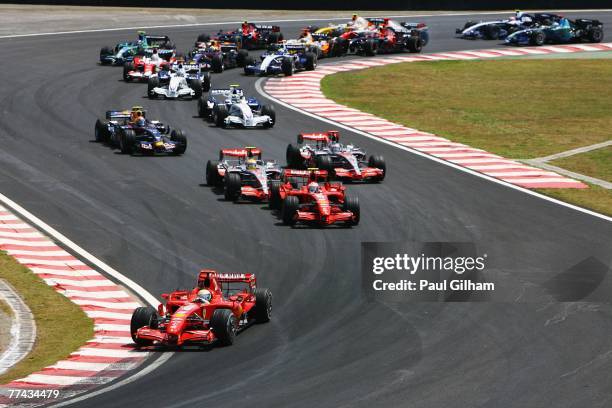 Felipe Massa of Brazil and Ferrari leads into turn one as Kimi Raikkonen of Finland and Ferrari overtakes Lewis Hamilton of Great Britain and McLaren...