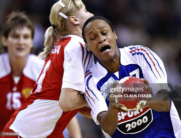 France 's Allison Pineau fights for the ball with Irina Bliznova of Russia during their women's GF World Cup handball finals, 21 October 2007 in...