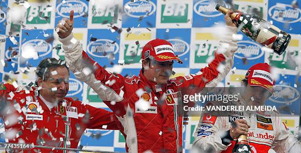 Finnish Formula One driver Kimi Raikkonen celebrates with Ferrari team mananger Jean Todt and Spanish Fernando Alonso his F-1 World Champion title...