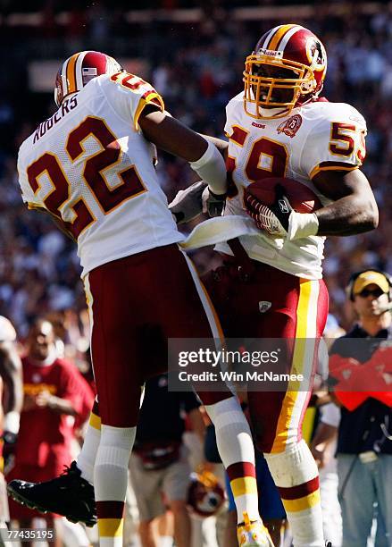 Linebacker London Fletcher and cornerback Carlos Rogers of the Washington Redskins celebrate after Fletcher scored a touchdown on an interception...