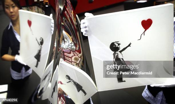 'Balloon Girl' 2003 by artist Banksy is held by Bonham's Andrea Lee and is reflected in a mirror polished vase entiled 'B.O.O.P. By Ron Arad on...