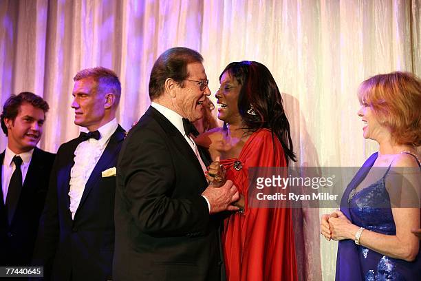 Christian Moore, Dolph Lundgren, Honoree Sir Roger Moore greets Bond girl Trina Parks and Bond girl Luciana Paluzzi during the Thalians 52nd...