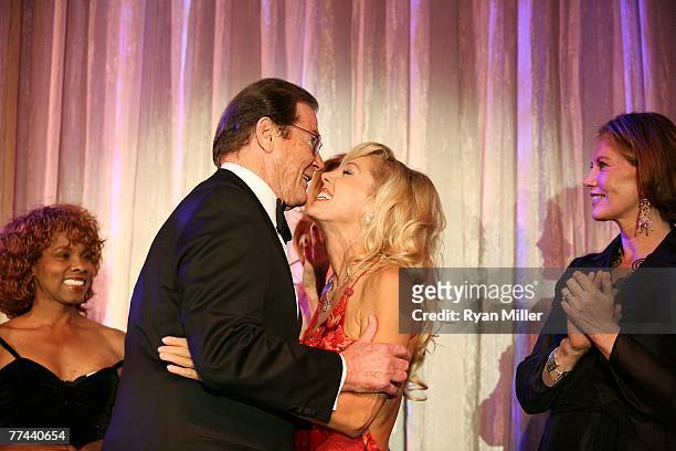 Bond girl actress Gloria Hendry Honoree, Sir Roger Moore kisses actress Lynn Holly Johnson and Bond girl Maud Adams during the Thalians 52nd...