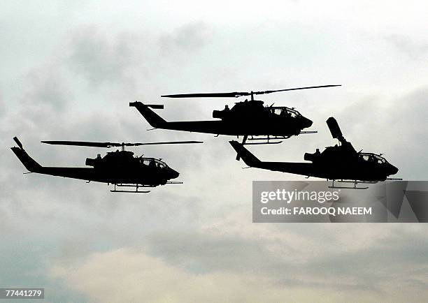 In this picture taken 16 March 2005, Pakistani army pilots display their skills with Cobra helicopters during a rehearsal for National Day...