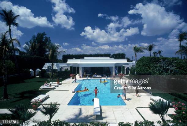 Bathers in and around the pool at Mrs. Murray Goodman's house in Palm Beach, Florida, April 1985.