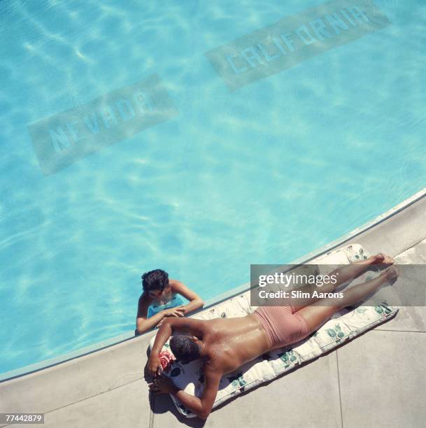 Couple at a swimming pool at the Cal Neva Lodge on the shore of Lake Tahoe, USA, 1959. The Cal Neva resort and casino straddles the border between...